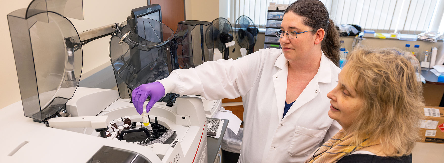 Researchers in lab looking at centrifuge